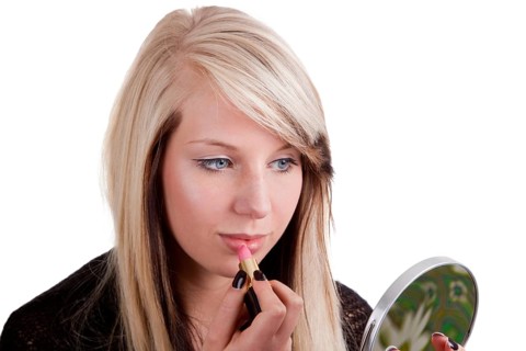 Young woman applying make-up - cropped on a white background