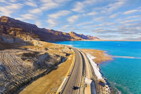 Sunset. Dead Sea photographed from a drone. Evaporated salt was deposited along the shore. Asphalt