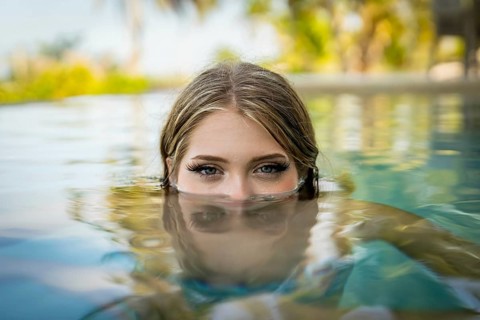 Young bikini model luxuriates in warm sun, cool pool, Yucatan Mexico vacation