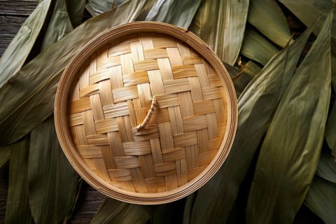 Asian kitchen bamboo steamer for steam cooking recipes on leafs