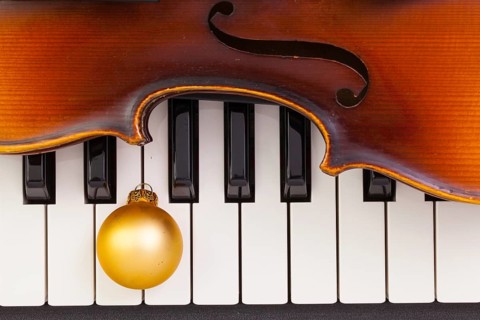 Top view close up shot of piano keyboard, old violin and Christmas decoration. Flat Lay Image
