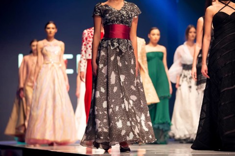 Female models walk the runway in beautiful colorful dresses during a Fashion Show. Fashion catwalk