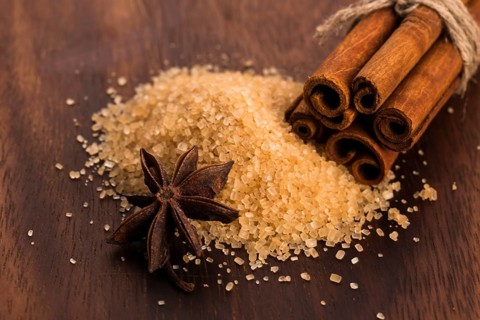 Cinnamon sticks with pure cane brown sugar on wood background