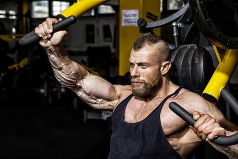 An image of a handsome bearded bodybuilding man doing chest workout