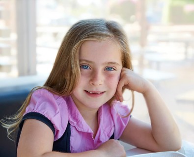 Blond relaxed happy kid girl expression blue eyes smiling