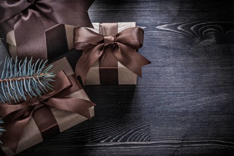 Fir branch Christmas gift boxes on wooden board holiday concept