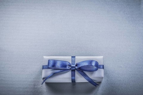 Wrapped gift box on blue background holidays concept
