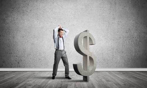 Young furious businessman going to crash with hands stone dollar symbol