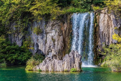 Charming little waterfall with a vertical ledge. Cascading Plitvice lakes in Croatia on a cloudy
