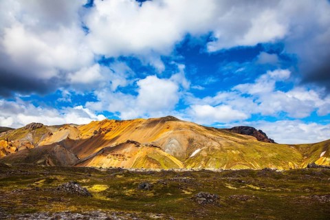 Multi-colored rhyolite mountains - orange, yellow, green and blue. Travel to Iceland in July,