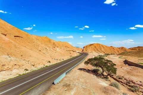 Straight as an arrow the road crosses the hills. Dry waterless hills of yelloy and beige clay.