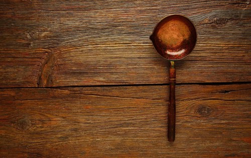 Aged cooper ladle vintage on wooden table retro