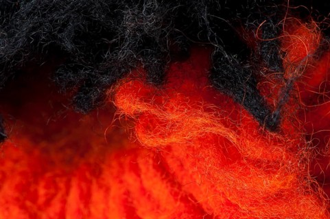Black and red wool fibers closeup