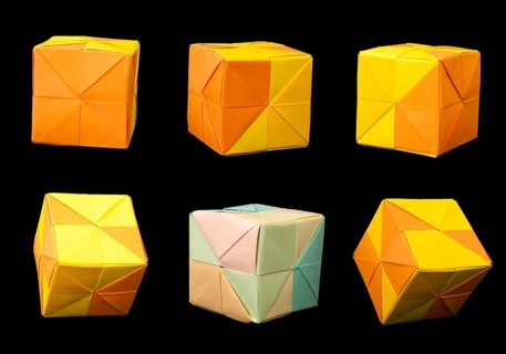 Paper made multi colored patterned cubes folded origami style. Yellow and orange colors