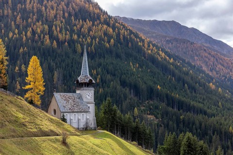 Church of St. Peter with golden larch in autumn, Monstein, Davos, Grisons, Switzerland, Europe