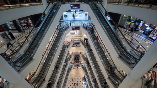 High angle shot of modern multistorey shopping mall. People traffic on the escalators of each floor