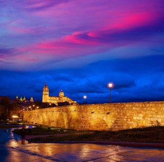 Salamanca skyline sunset and roman bridge over Tormes river in Spain