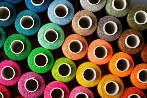Sewing threads multicolored background closeup