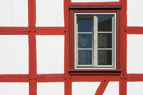 Close-up of the beam construction of a half-timbered house with windows