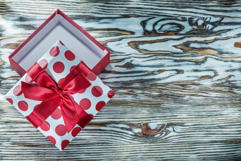 Red packed gift box on vintage wooden board