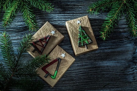 Handmade present boxes fir tree branch on wooden board