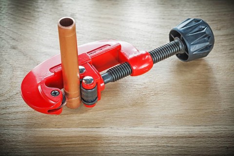 Flared pipes pipe cutter on wooden board top view