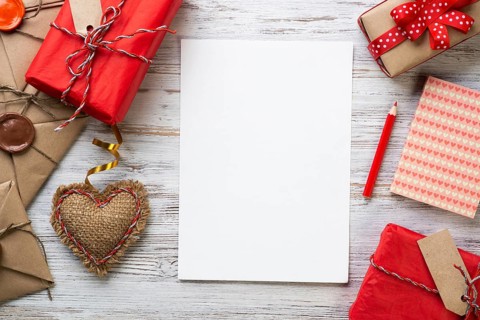 White paper and retro mail envelopes on wooden table. Flat lay cute composition with handmade