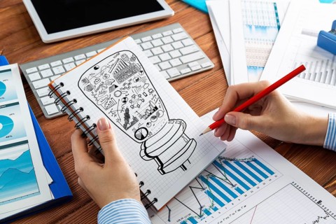 Close-up, woman draws business notes in her notebook. Business Innovation Concept