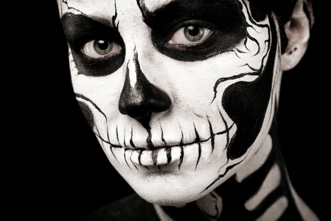 Isolated on black, closeup picture, beautiful young brunette caucasian woman with scull body art,