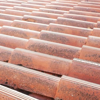 Old tiled roof. Close up of the red clay roof tiles. Background of old roof
