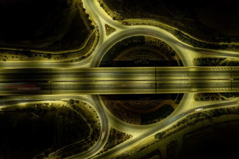 Aerial drone top view of motorway junction. Roundabout with cars moving. Transportation