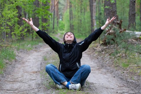 A man in the forest. A middle-aged woman sits on a forest path