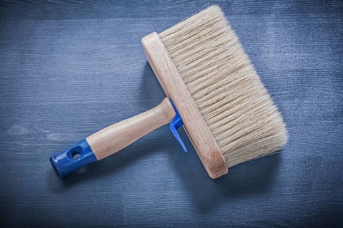 Wood board with paintbrush thick bristle construction concept