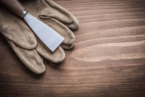 Paint scraper on protective glove