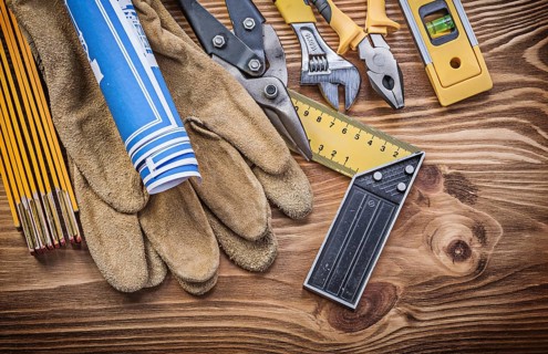 Stack of construction tools on vintage wooden board