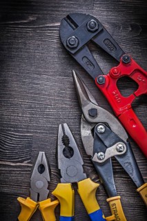 Metal wire steel cutter pliers on wood board construction concept