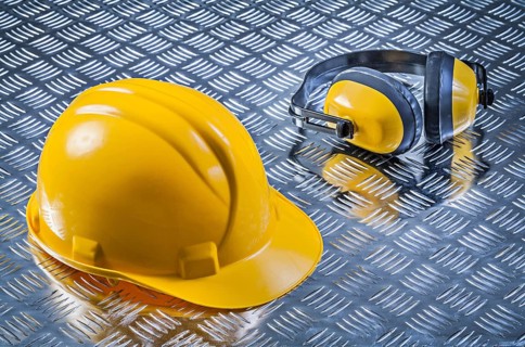 Safety earmuffs hard hat on fluted metal sheet construction concept
