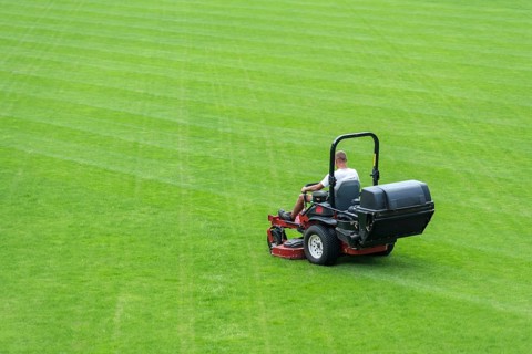 Mowing grass at football pitch in Lubin, Poland, Europe