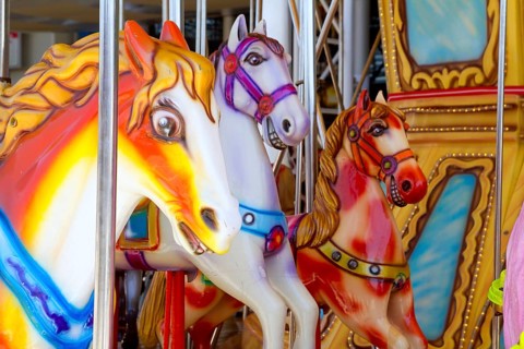 Horses in merry go round fairground attraction