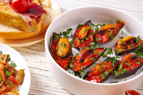 Tapas mix and pinchos food from Spain recipes also pintxos on a white wood board