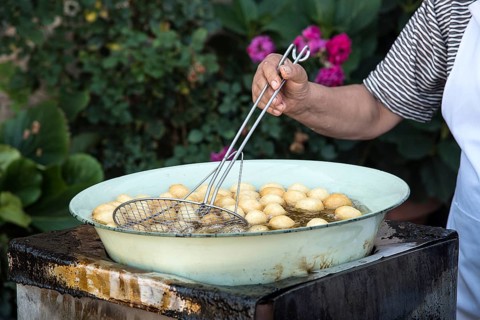 Woman cooking traditional delicious greek loukoumades honey pastry
