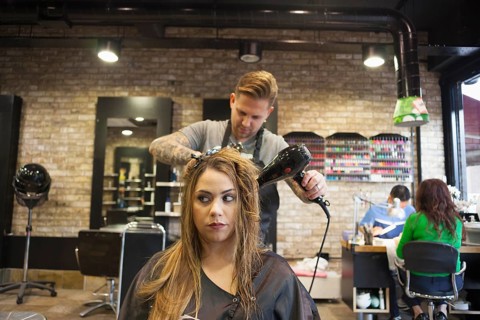 A Woman having her hair blowdried in hipster barbershop