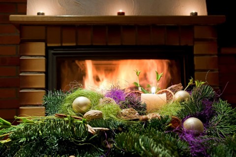 Christmas floral table decoration in front of the fireplace with candles