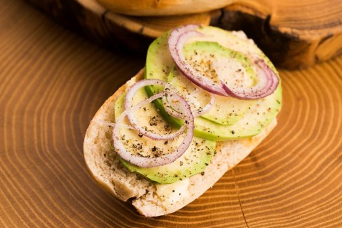Sandwich with avocado, red onion, salt and herbs