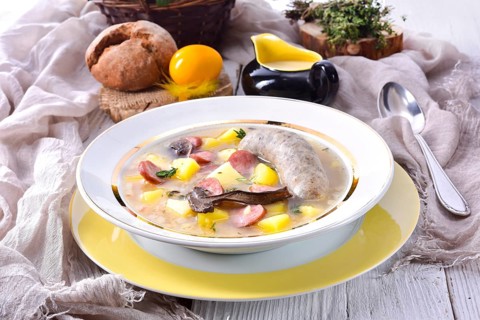 A polished Easter soup with homemade white sausages and mushrooms