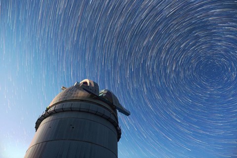 Astronomical observatory under the night sky stars. Blue sky with hundreds of stars of the Milky