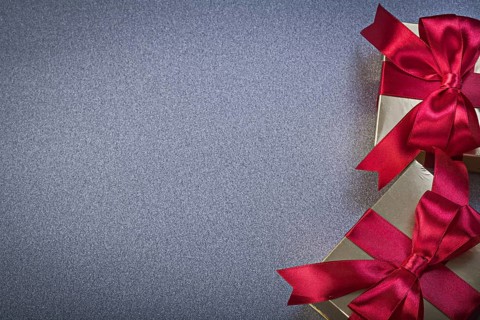Giftboxes with red tapes on grey background holidays concept