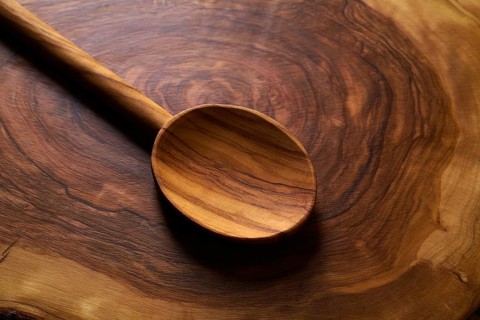 Olive wood spoon on same wooden cutting board
