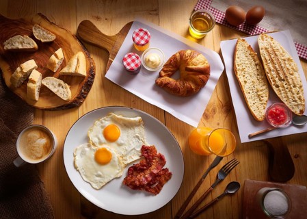 Continental breakfast croissant eggs bacon bread slices orange jiuce