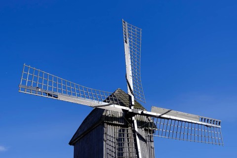 Windmill with wooden sails under a clear blue sky, traditional rural structure, borken,